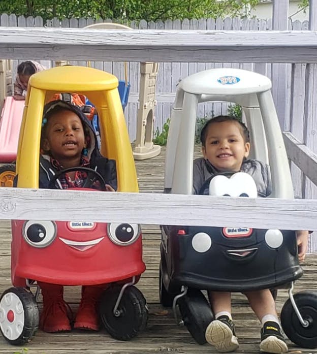 Two children in toy cars