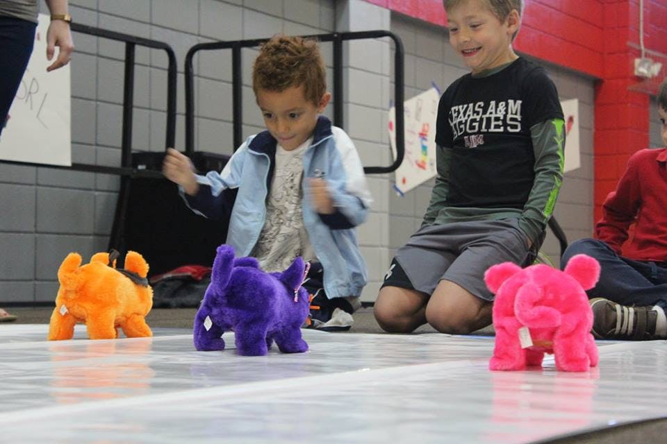 Child playing with toy animals on the floor