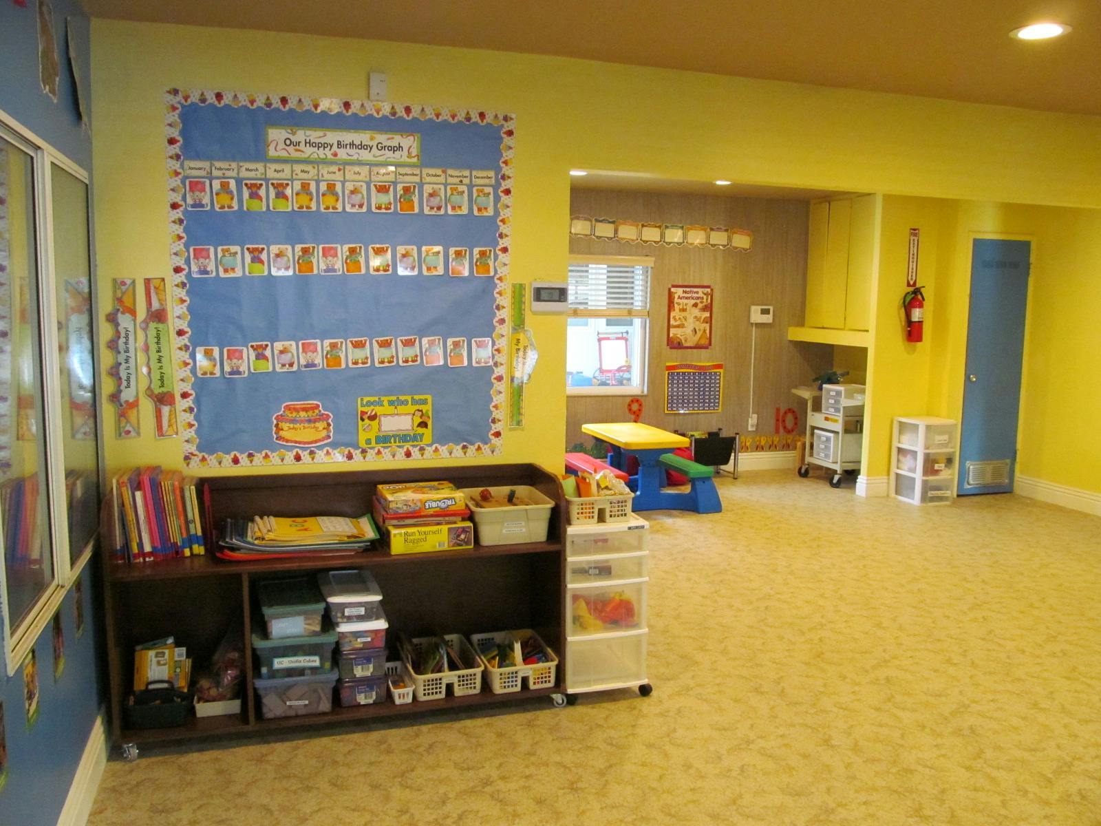 Classroom with bulletin board, bookshelf, and small table and chairs