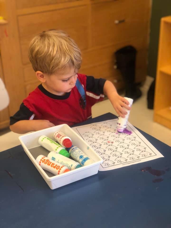 Child coloring a paper with a marker