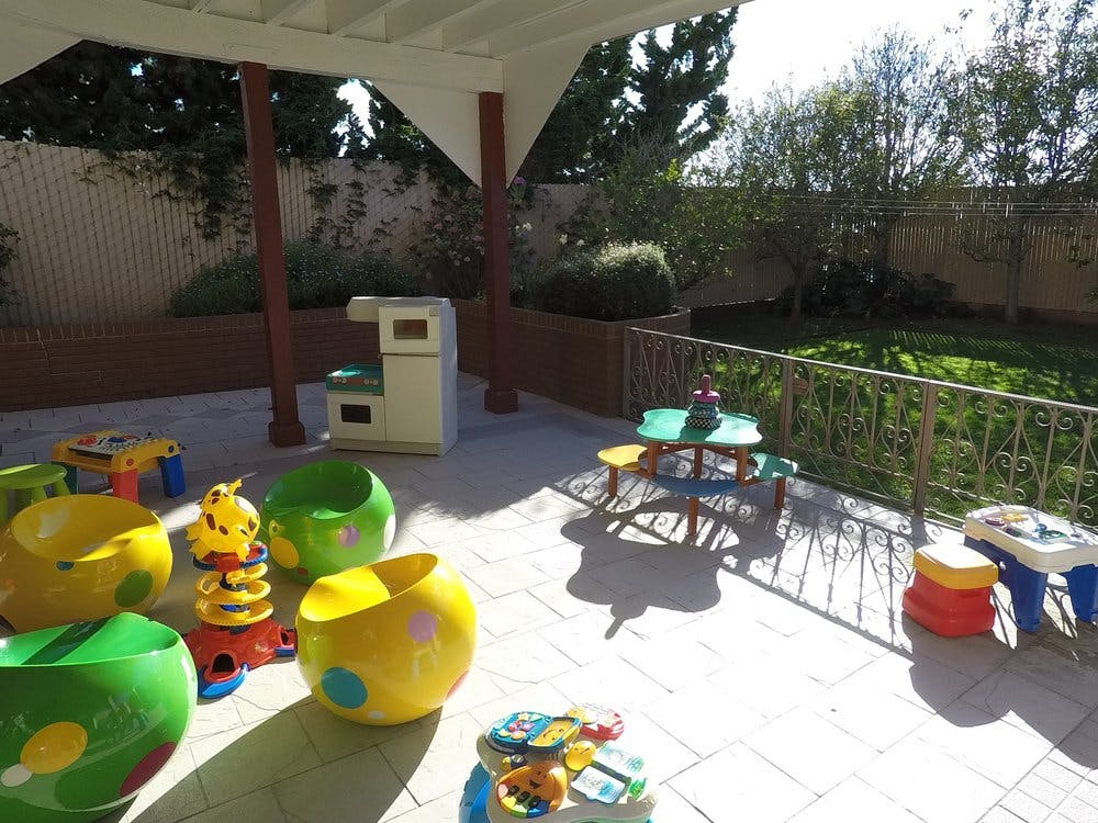 Outdoor patio with various colorful children's play equipment