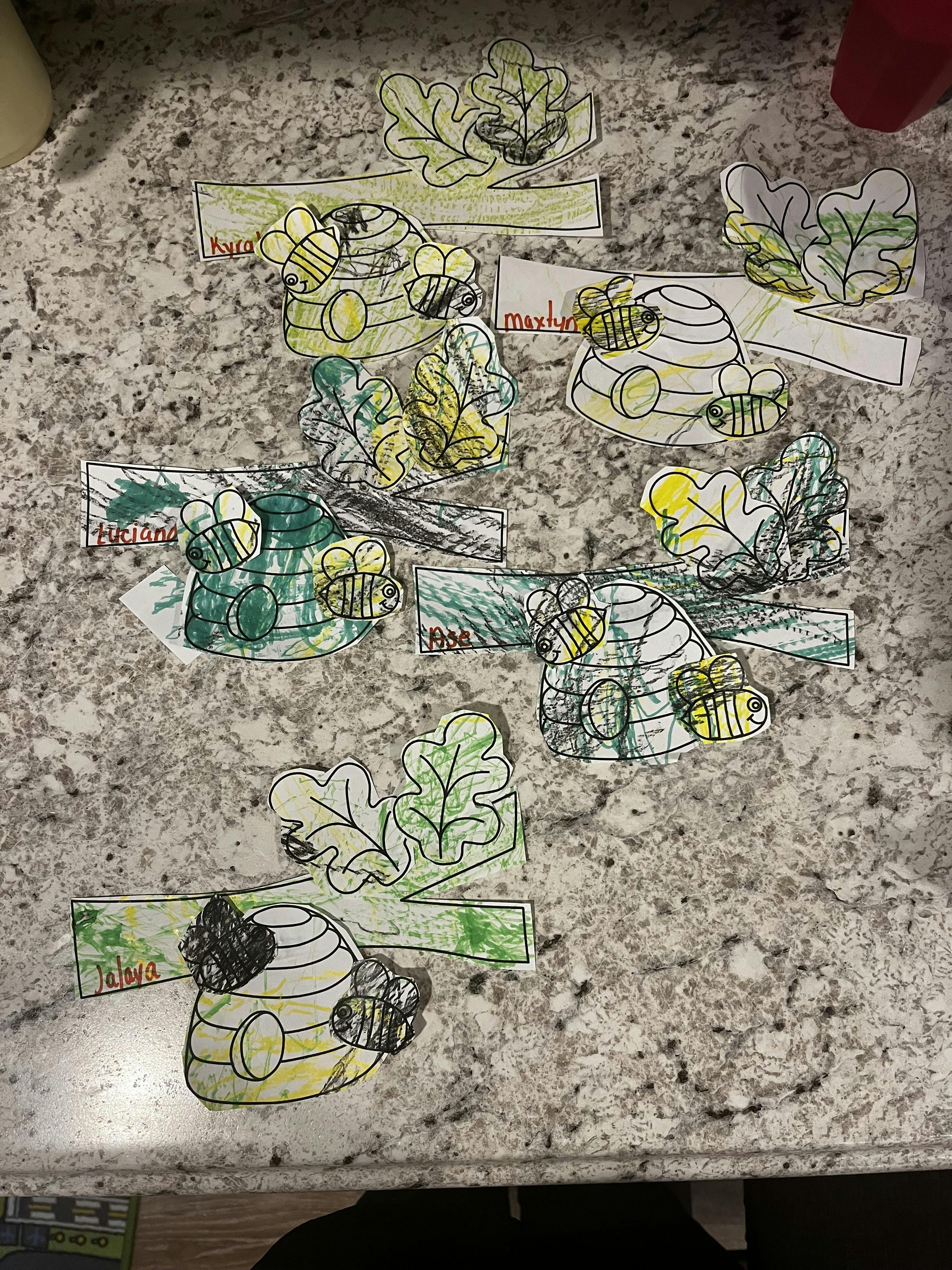 Multiple paper cutouts of beehives with bees and leaves