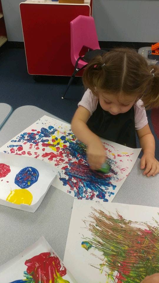 Child painting with a sponge on paper