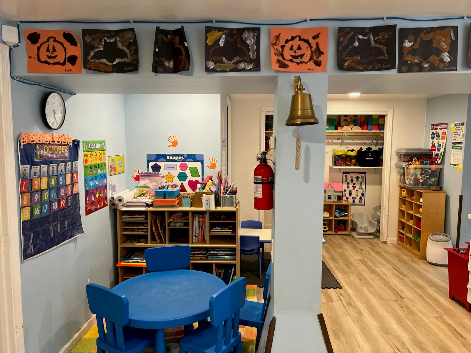 Children's classroom with blue table and chairs, shelves, and Halloween decorations