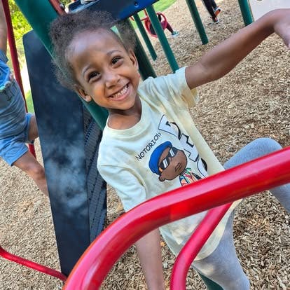 Child smiling on playground equipment