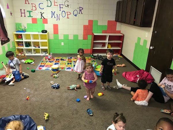 Children playing in a room with toys scattered on the floor
