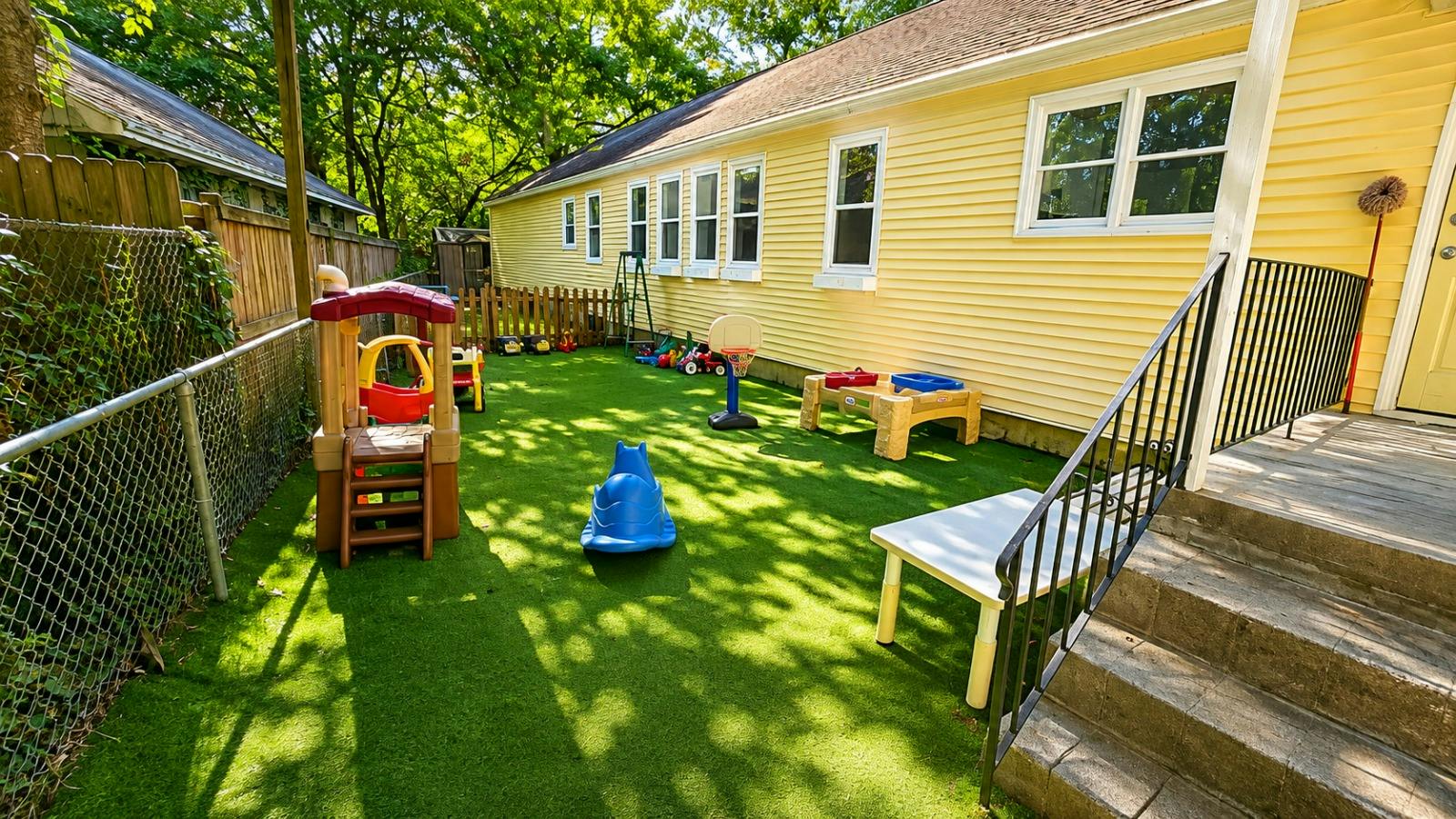 Playground equipment and small toys on an artificial turf backyard