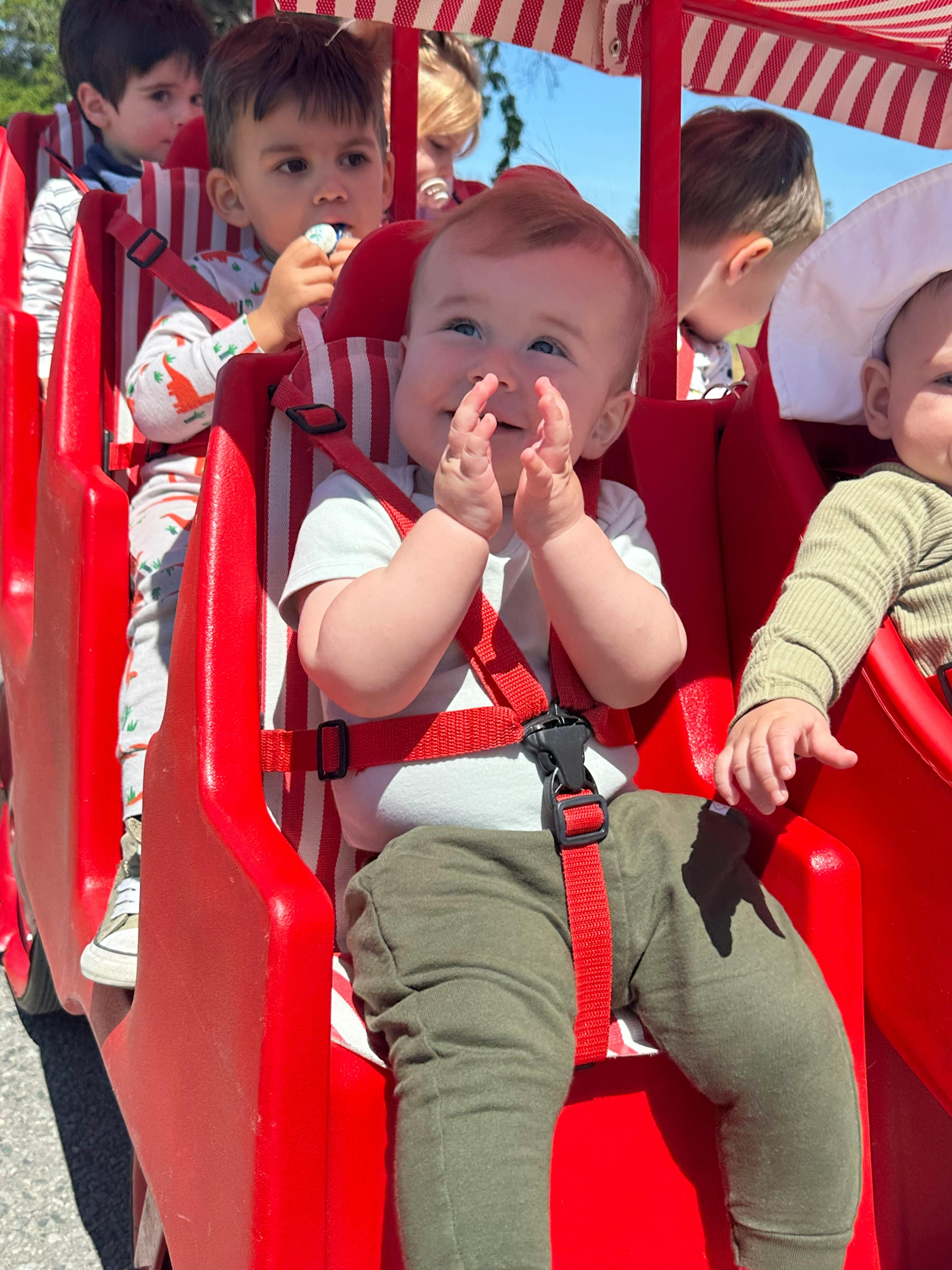 Child in a red seat with other children