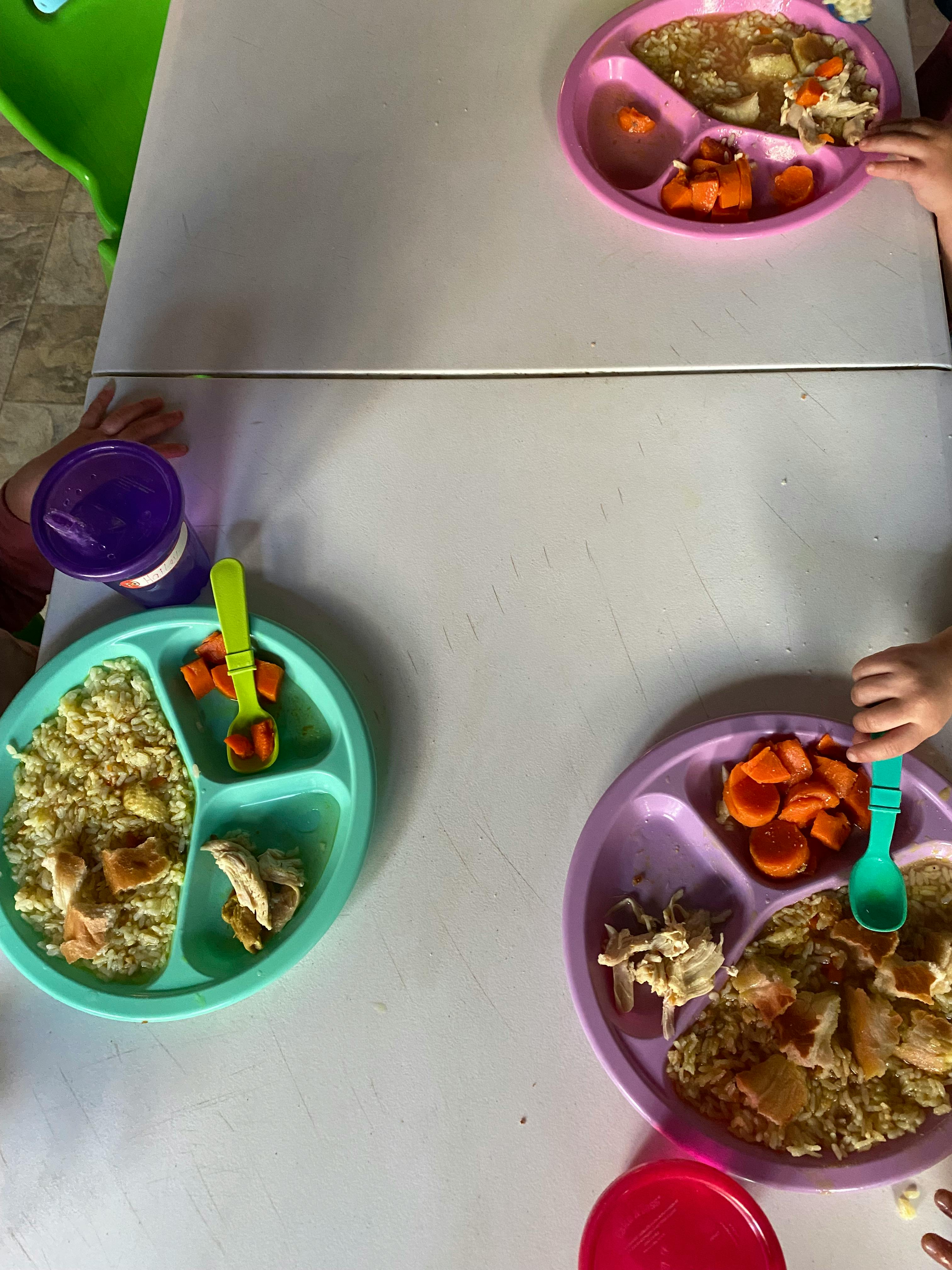 Three children's plates with food on a table