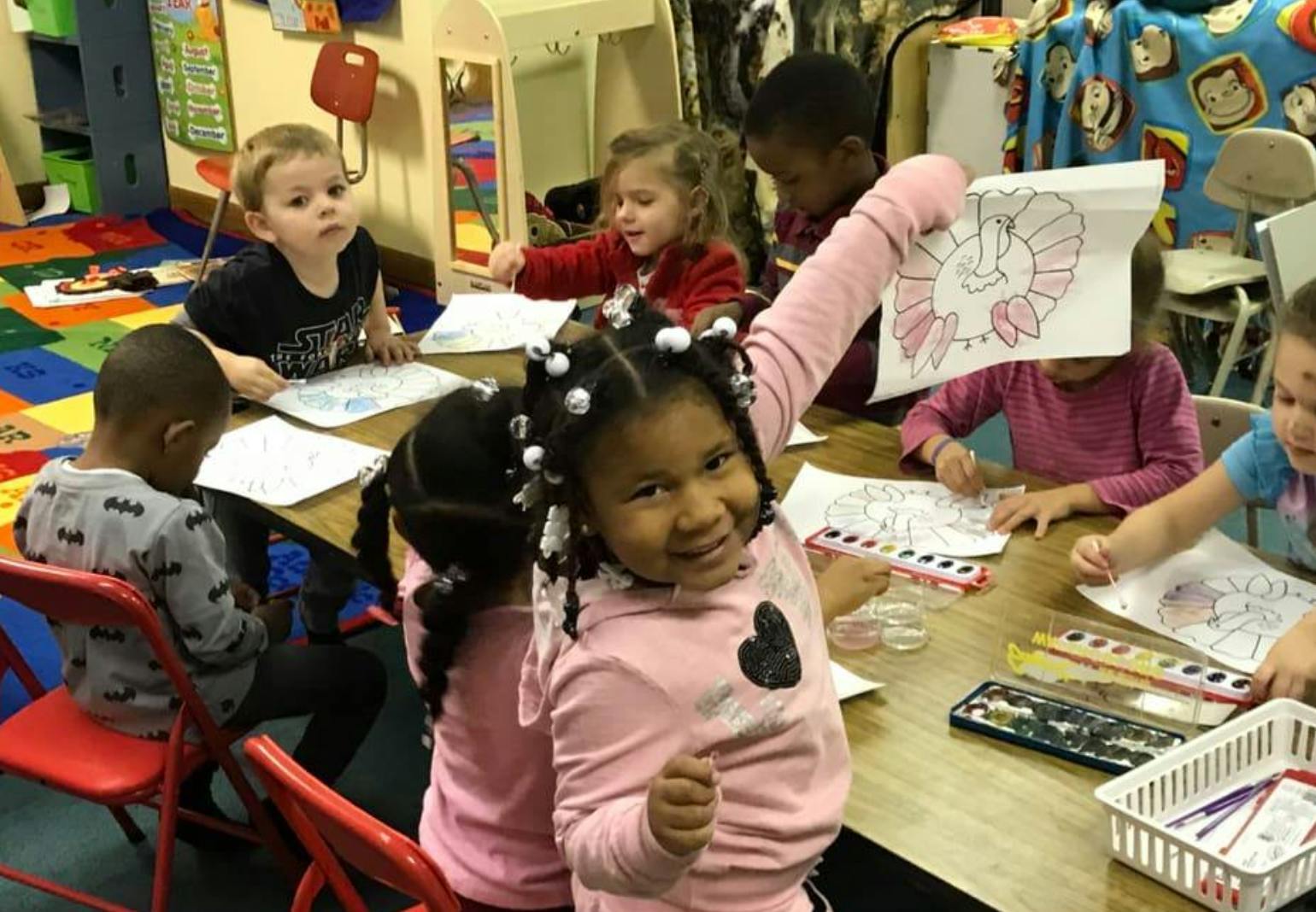 Children coloring at a table in a classroom