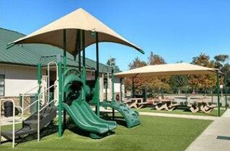 playground with green slides and a shaded picnic area