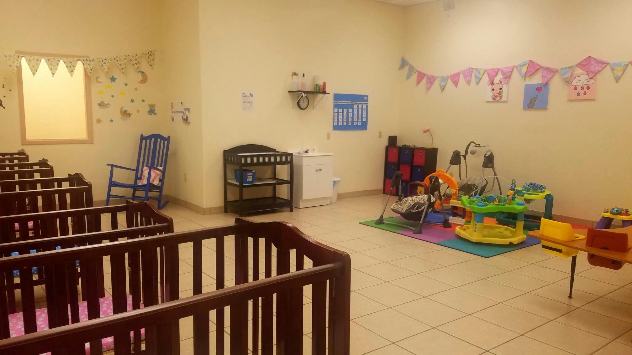 Nursery room with multiple cribs and play area