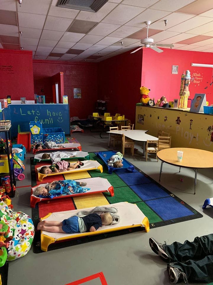Children sleeping on cots in a classroom