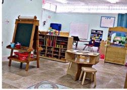 Classroom with easel, shelves, and small table with stool