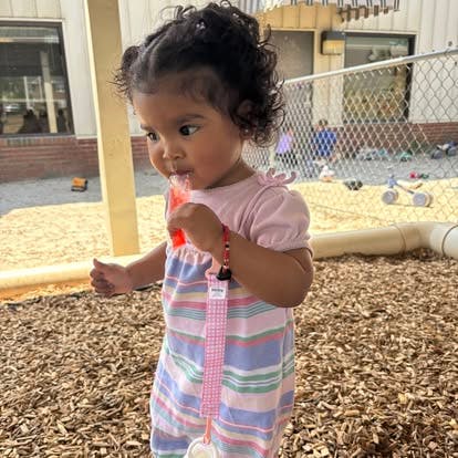 Child eating an ice pop in a playground area