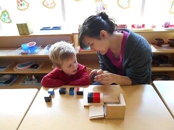 Adult and child at a table with blocks