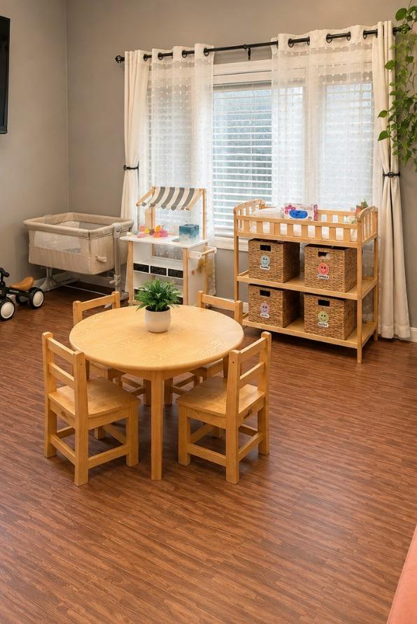 Child-sized table and chairs in a nursery room with a changing table and crib