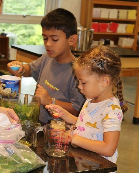 Two children preparing food in a kitchen