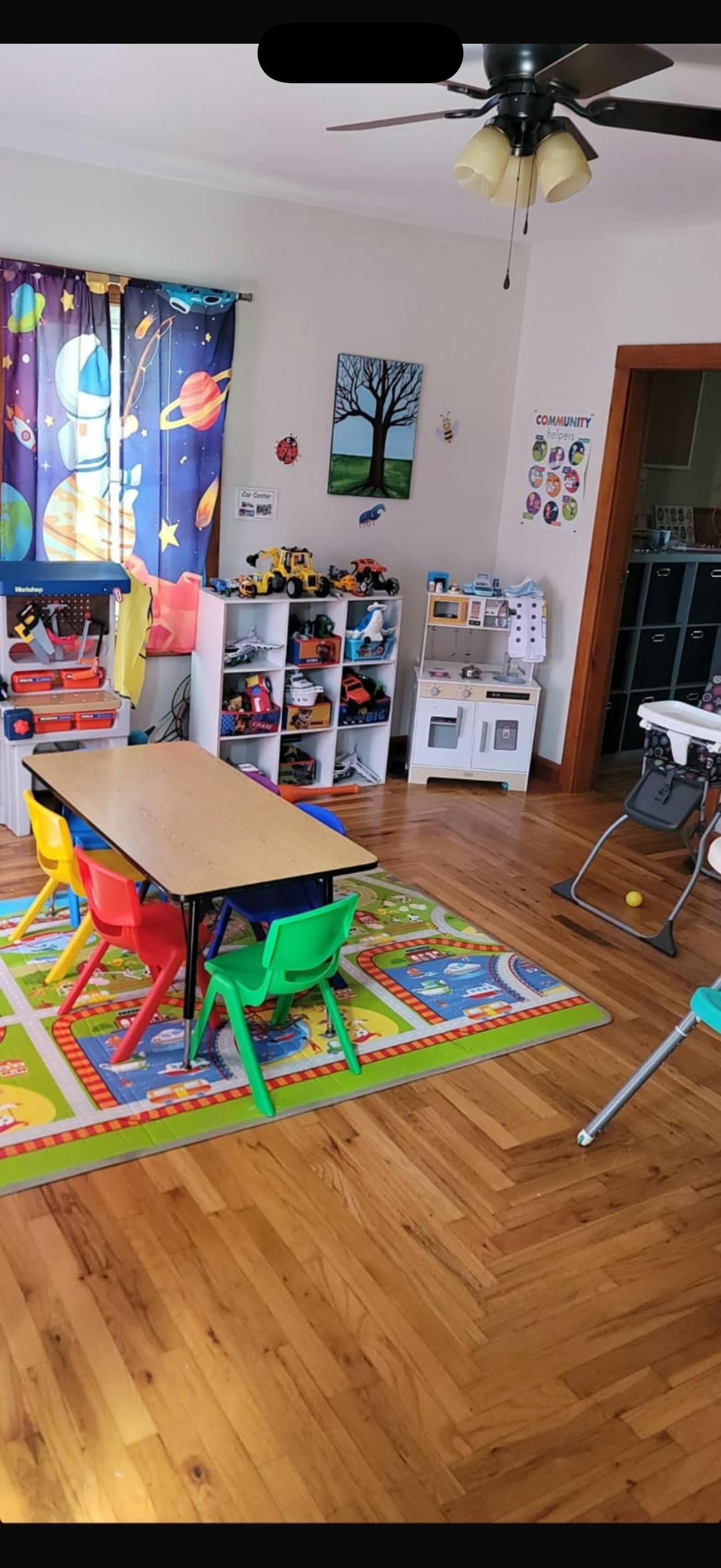 Children's play area with a table, chairs, and toy shelves