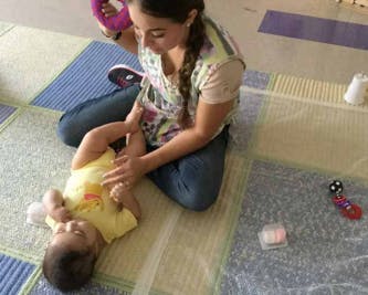 Person on floor interacting with an infant