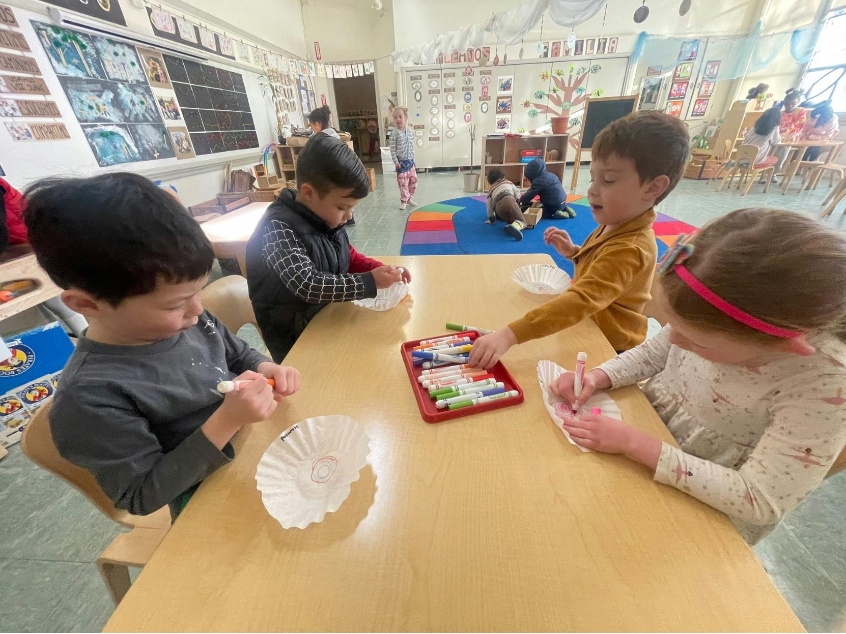 Children coloring at a table in a classroom