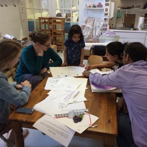 Adults and a child gathered around a table with papers