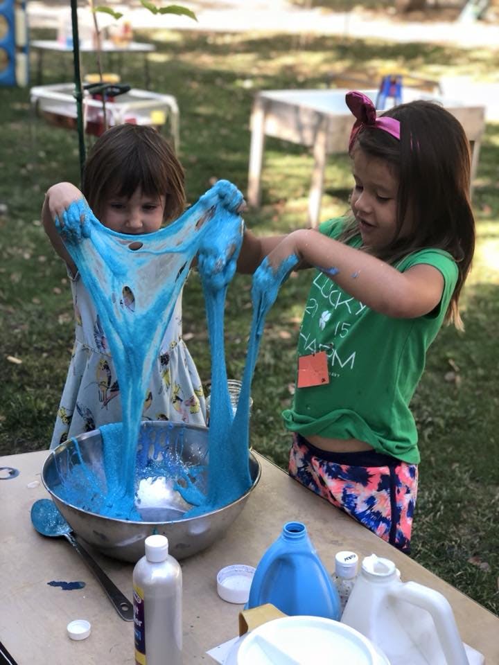 Two children playing with blue slime outdoors