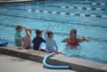 Four children and one person in a swimming pool