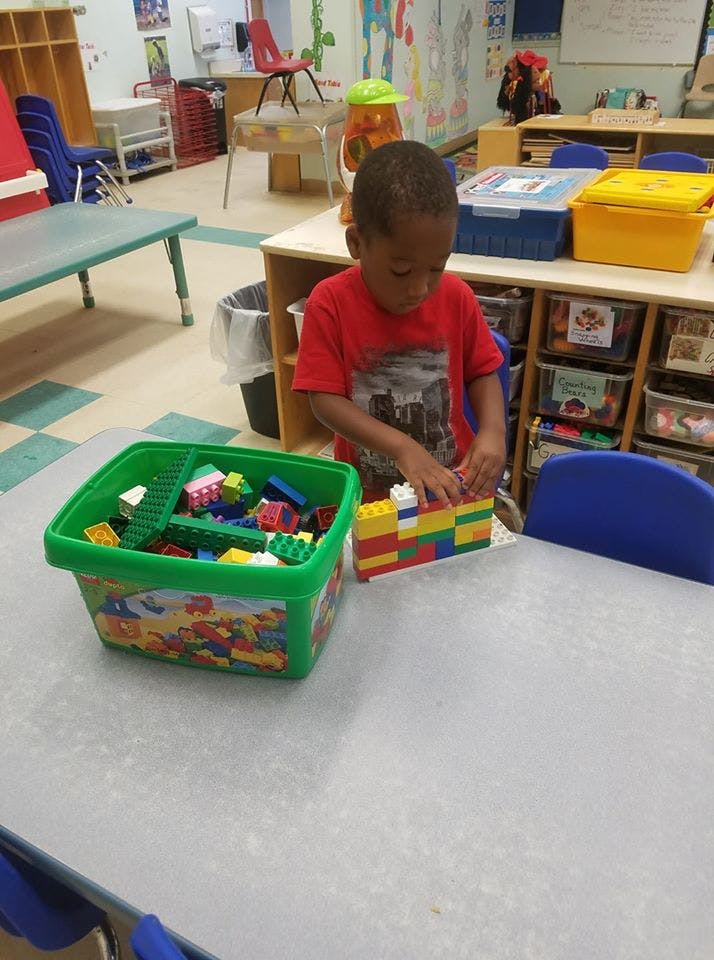 Child building with colorful blocks at a table