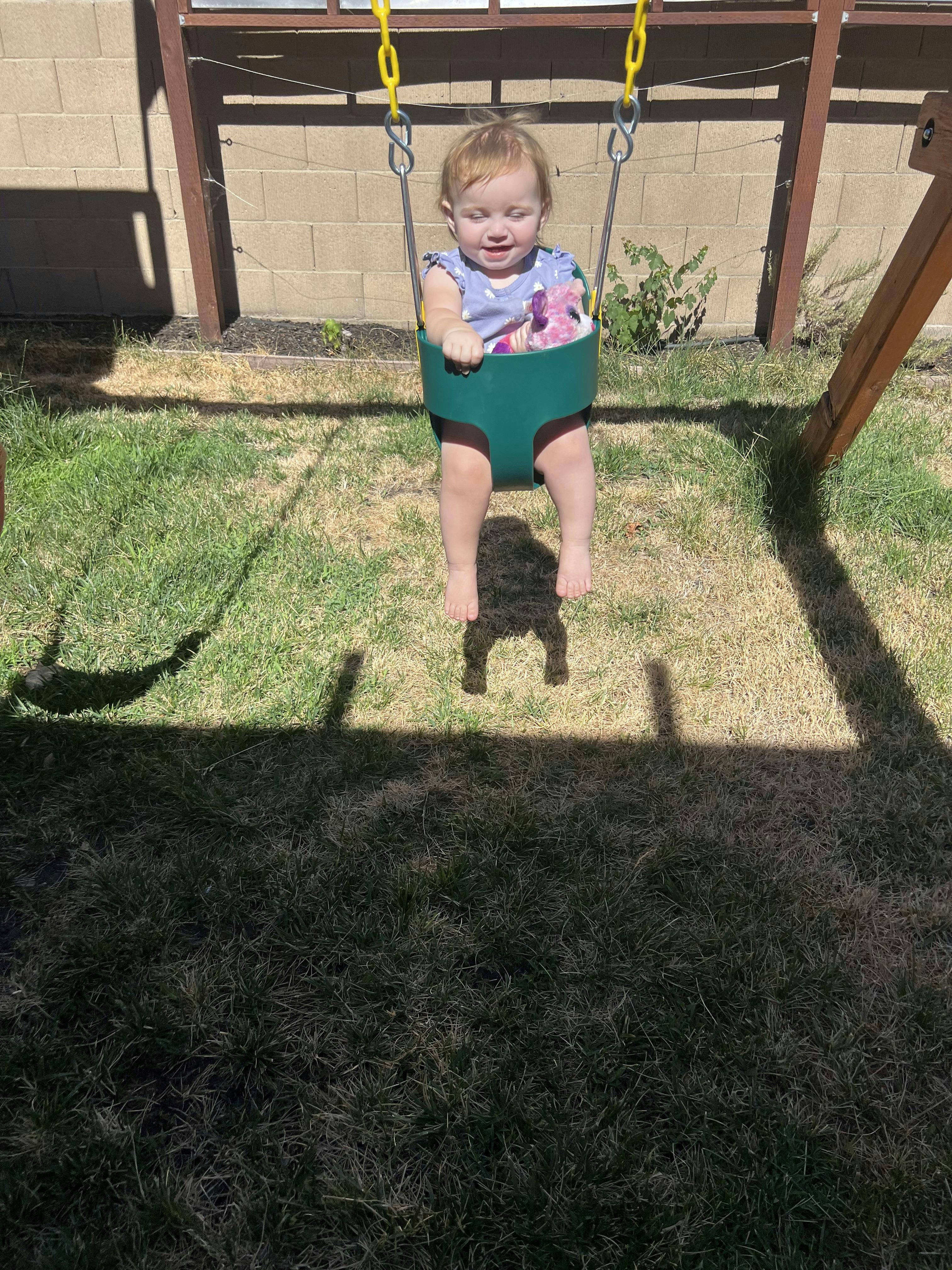 Child in a green swing seat on a swing set