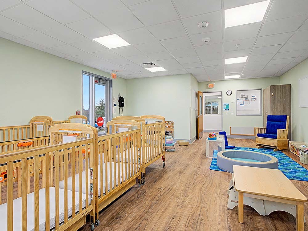 Cribs and small play area in a brightly lit room