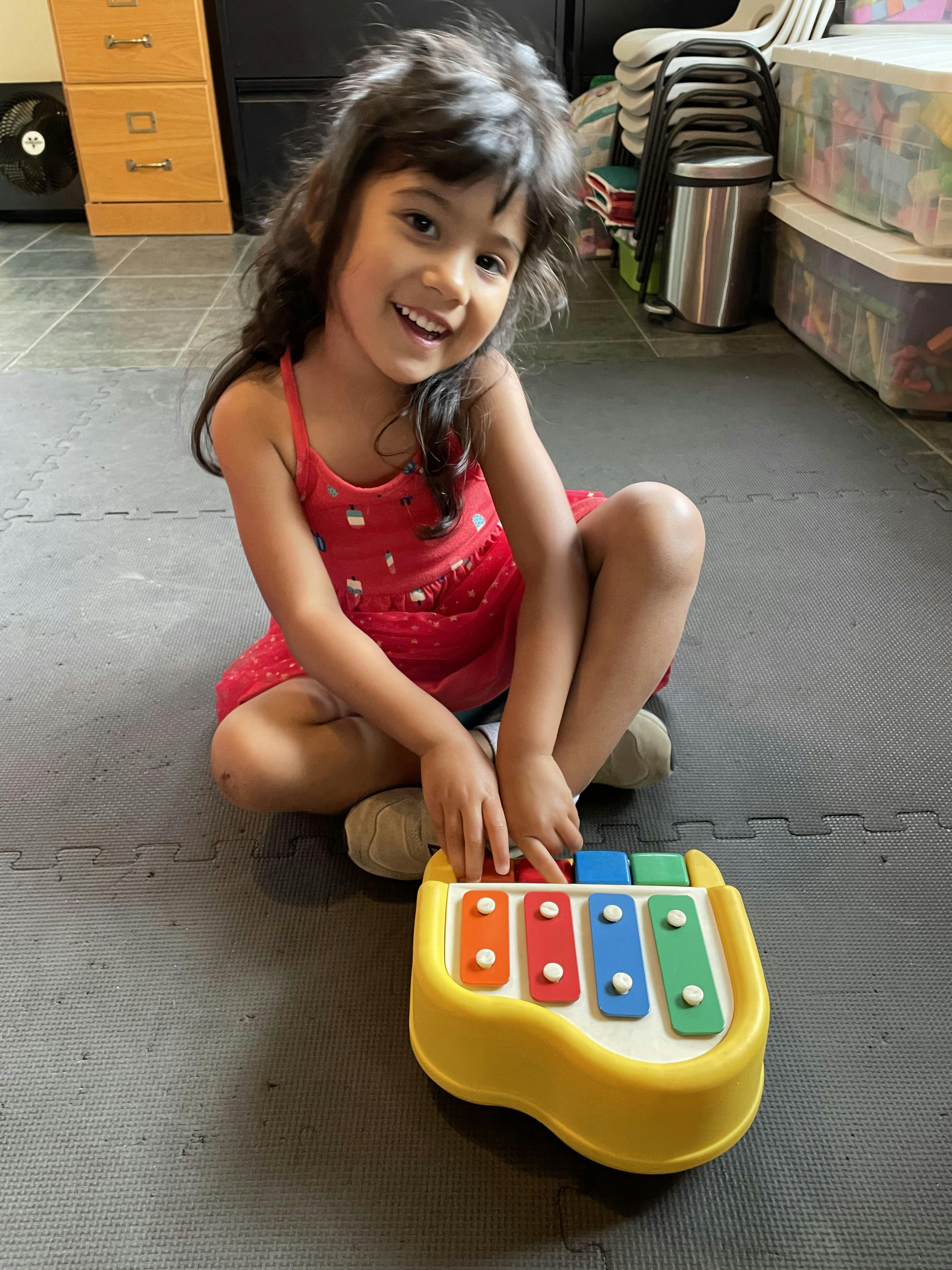 Child playing with a colorful toy xylophone