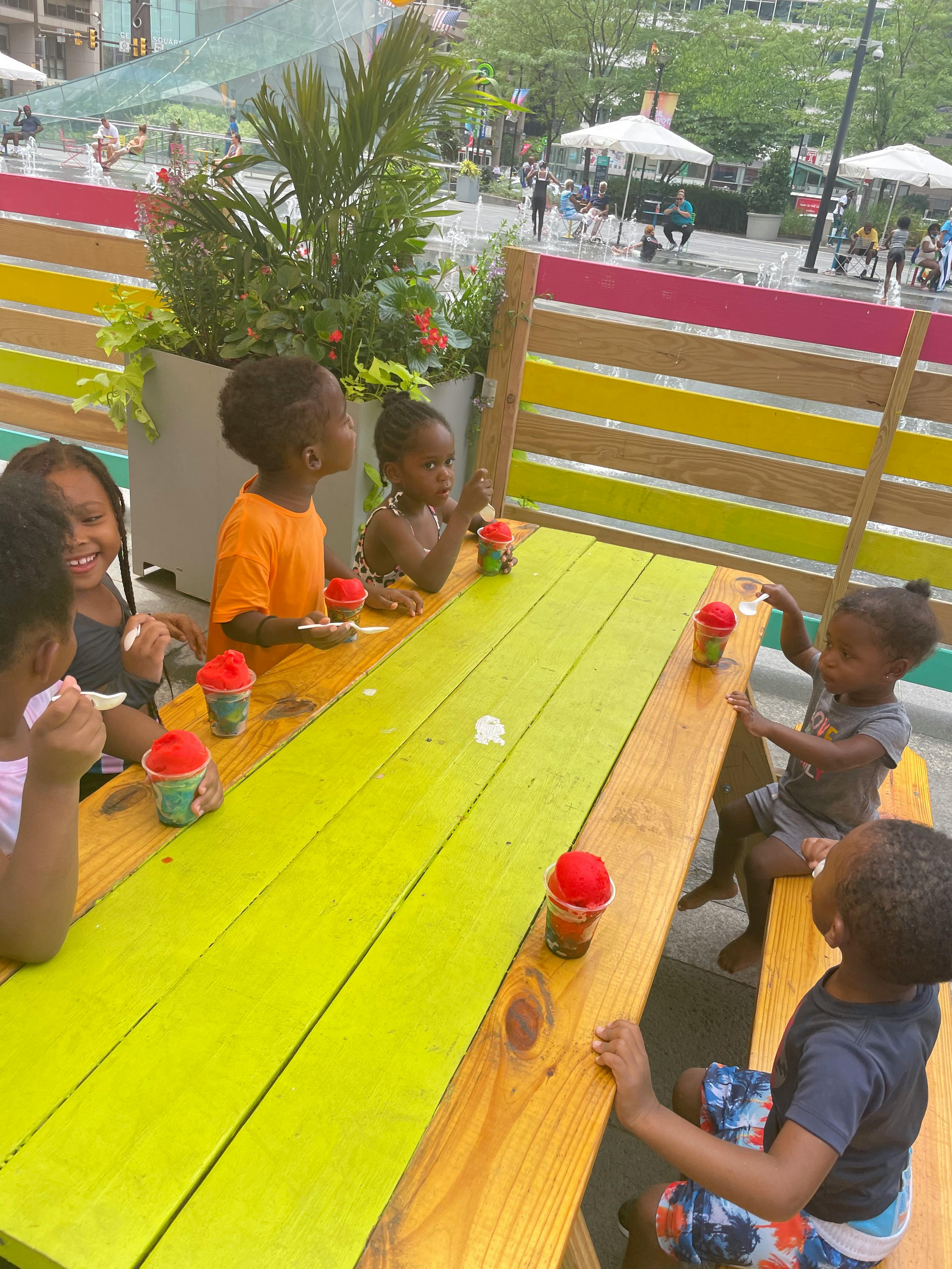 Children sitting at a picnic table with cups
