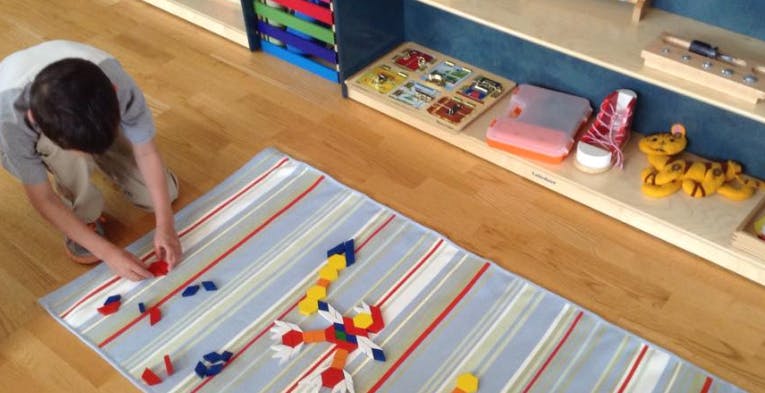 Child playing with colorful blocks on a striped rug