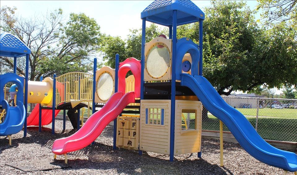 Child on a colorful playground structure with slides and tunnels