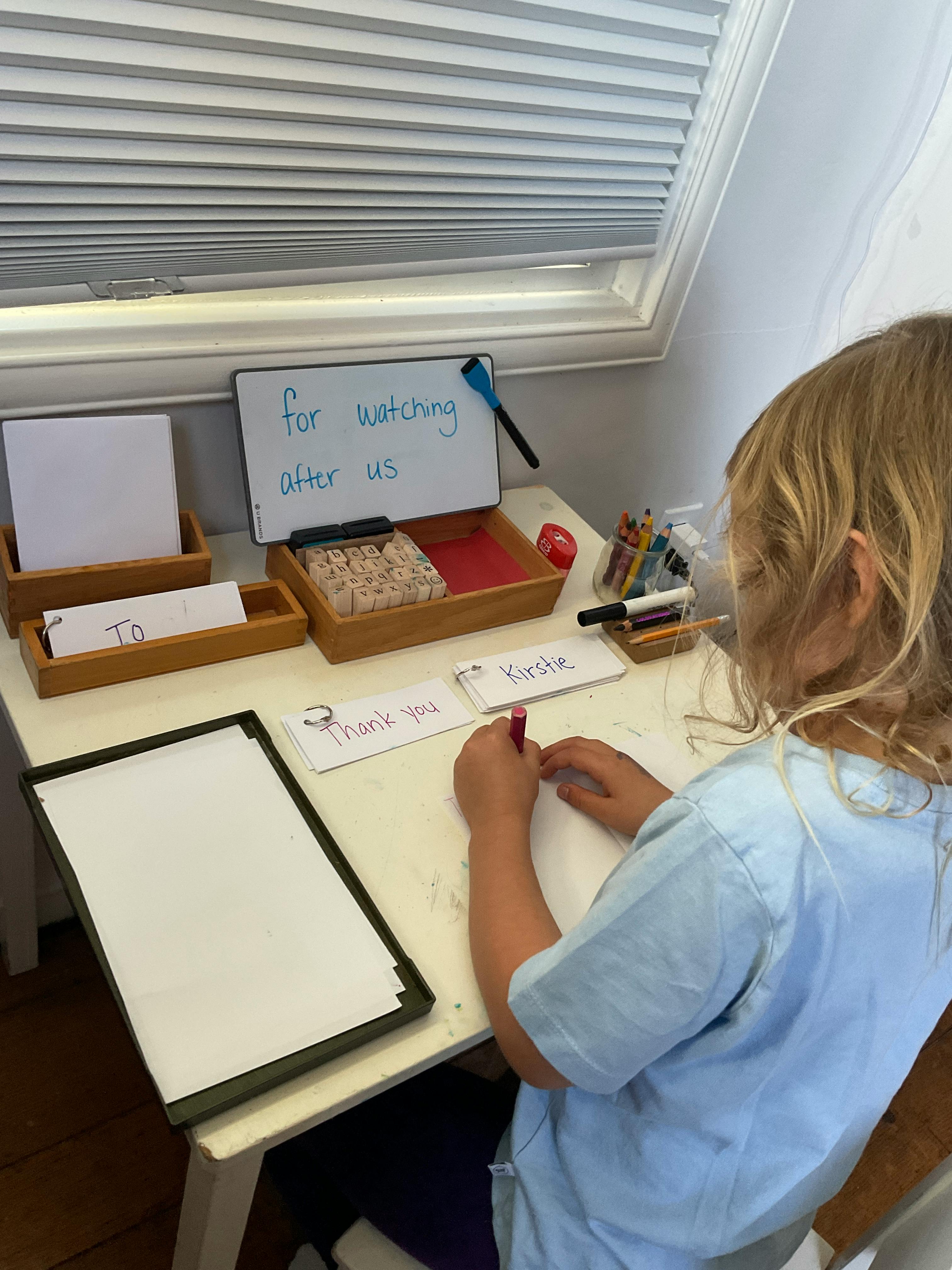 Child writing on paper at a desk