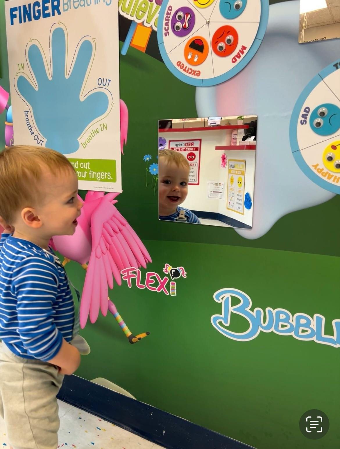 Child looking at their reflection in a mirror