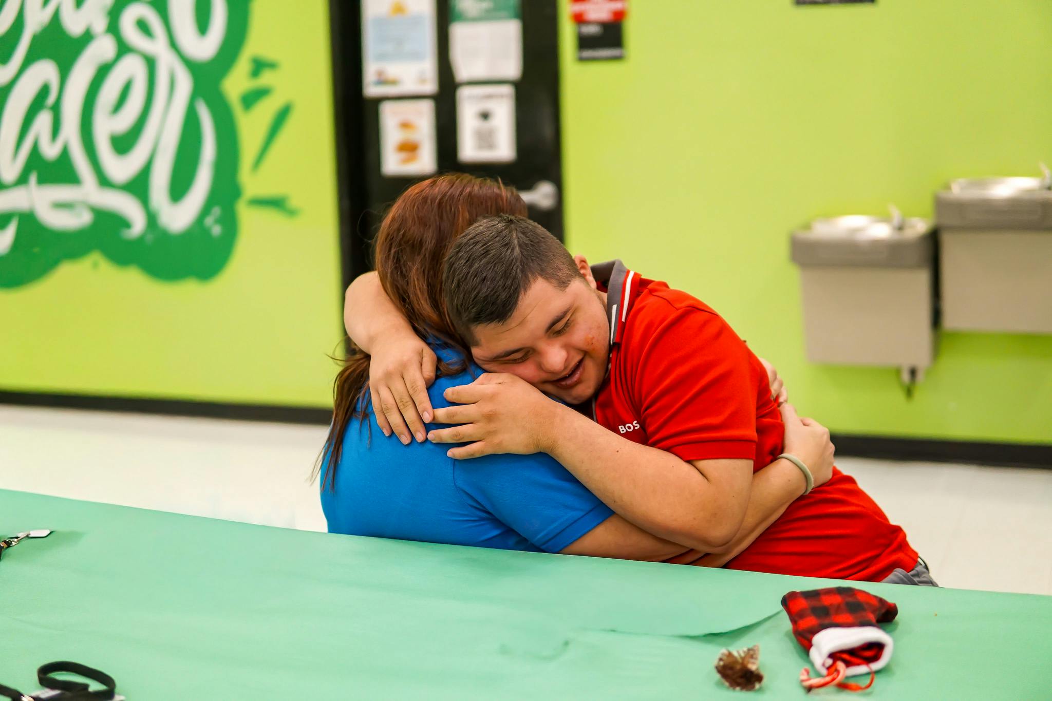 Two people embracing while seated at a table