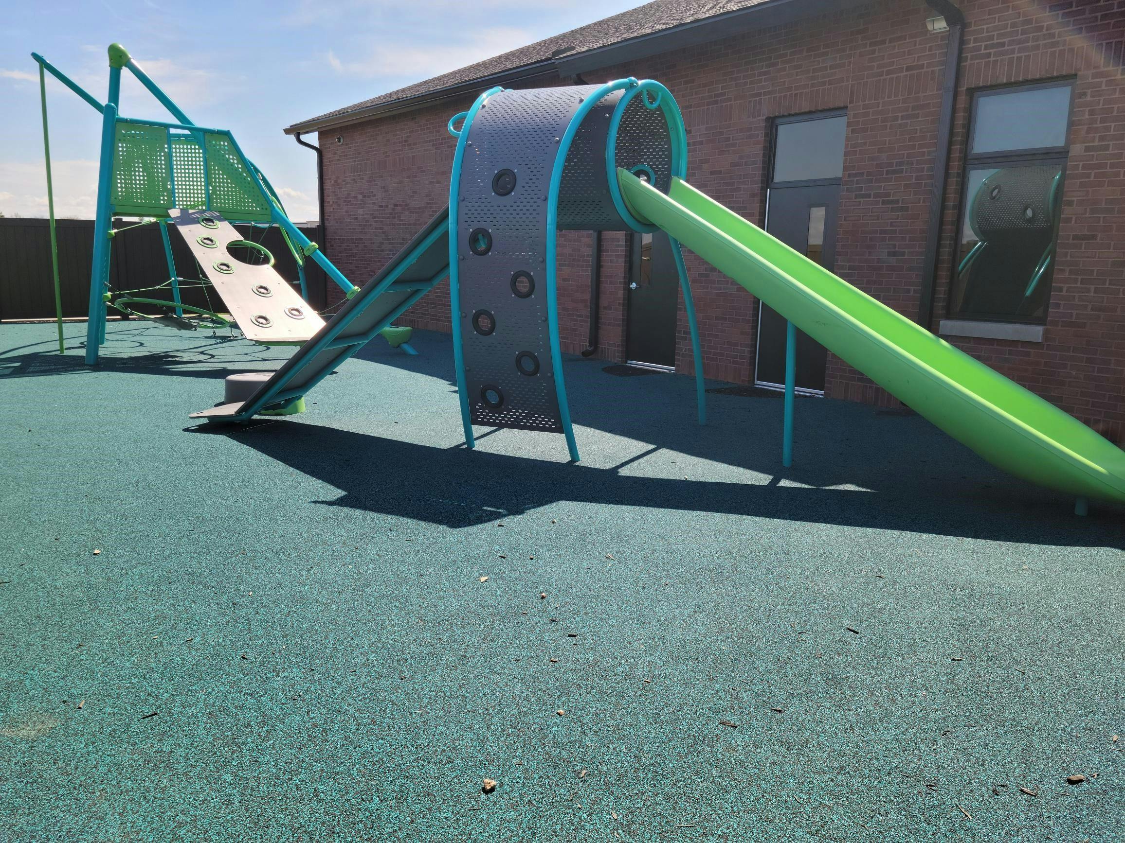 Playground with green slide and climbing structure