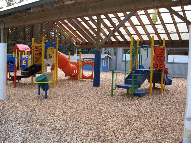 Playground with slides and climbing structures under a covered roof