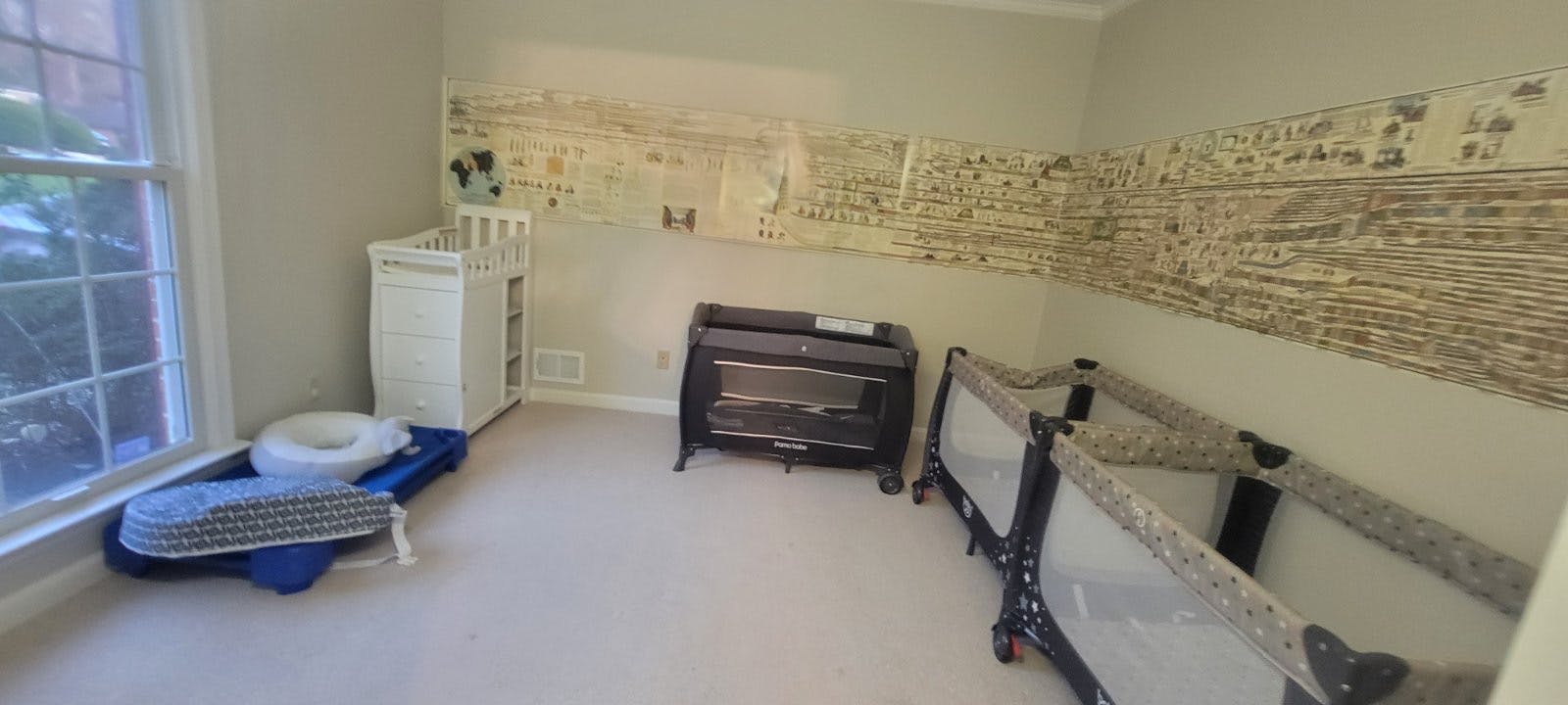 Room with two cribs, a changing table, and a potty training toilet