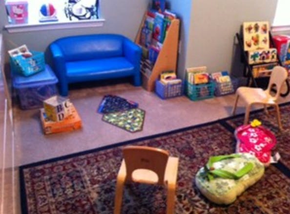 Playroom with small blue couch, bookshelves, and children's chairs