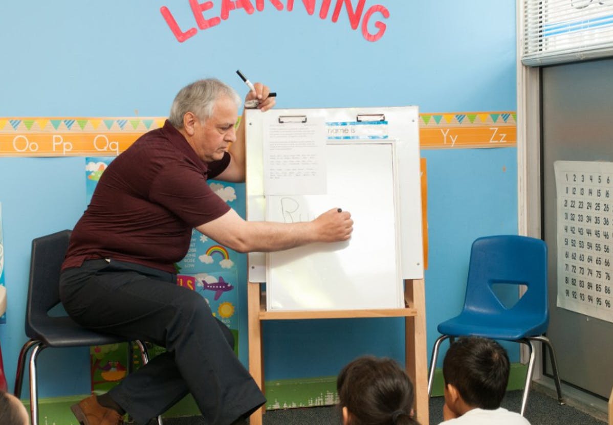Person writing on a whiteboard in a classroom