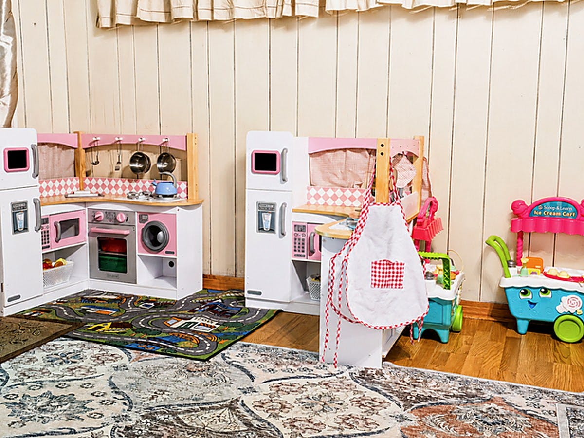 Toy play kitchens and an ice cream cart in a room