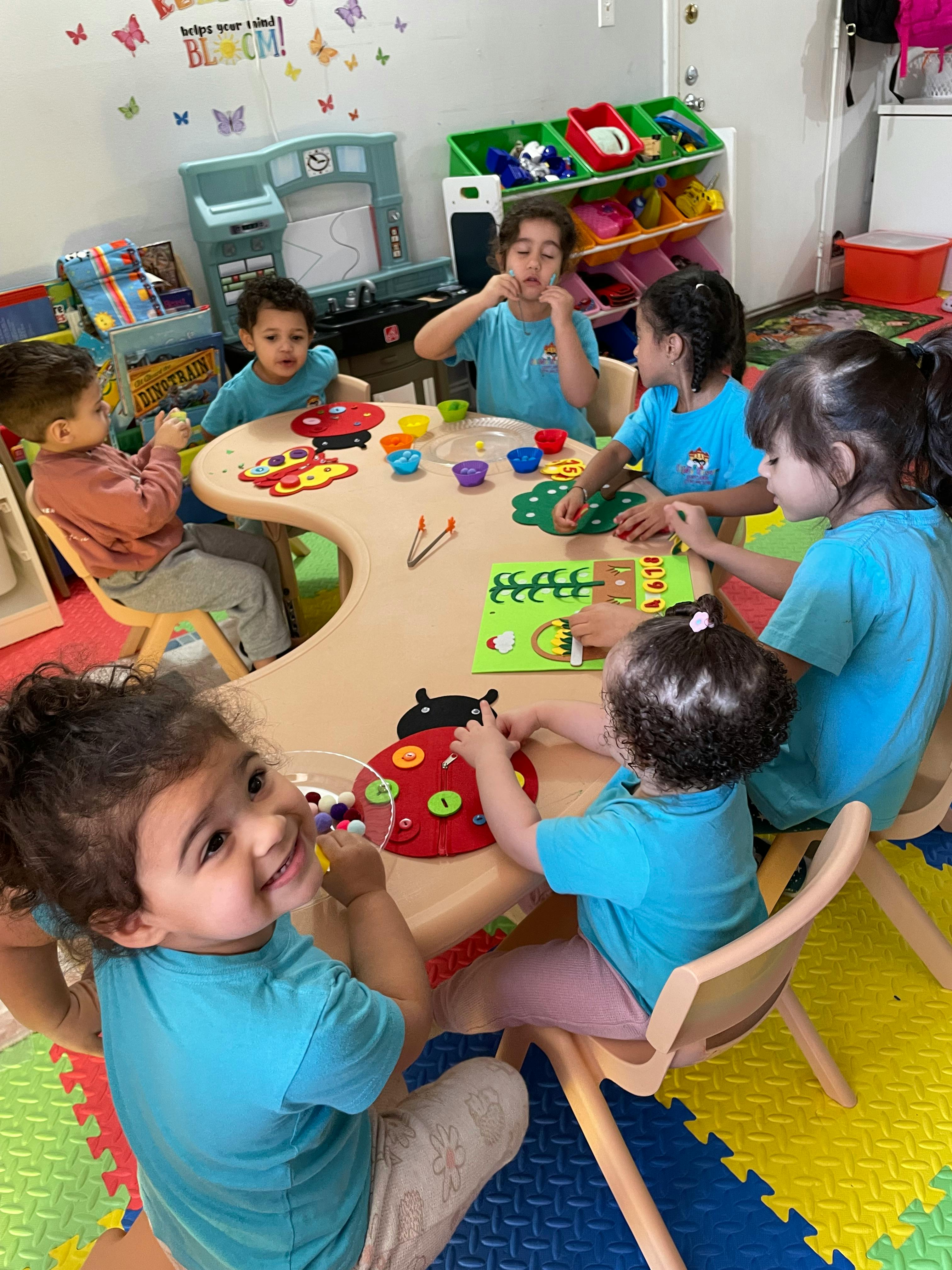 Children playing with toys at a table in a classroom