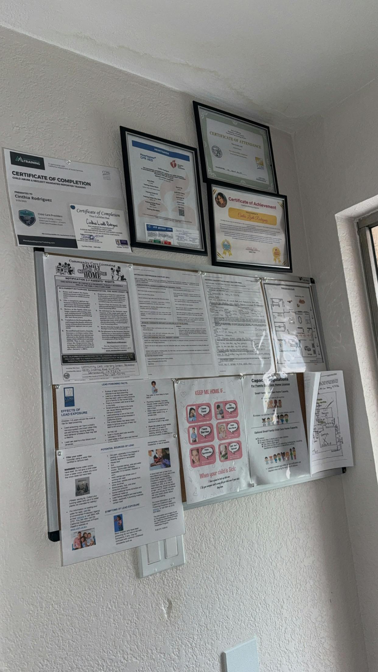 Documents and framed certificates displayed on a wall