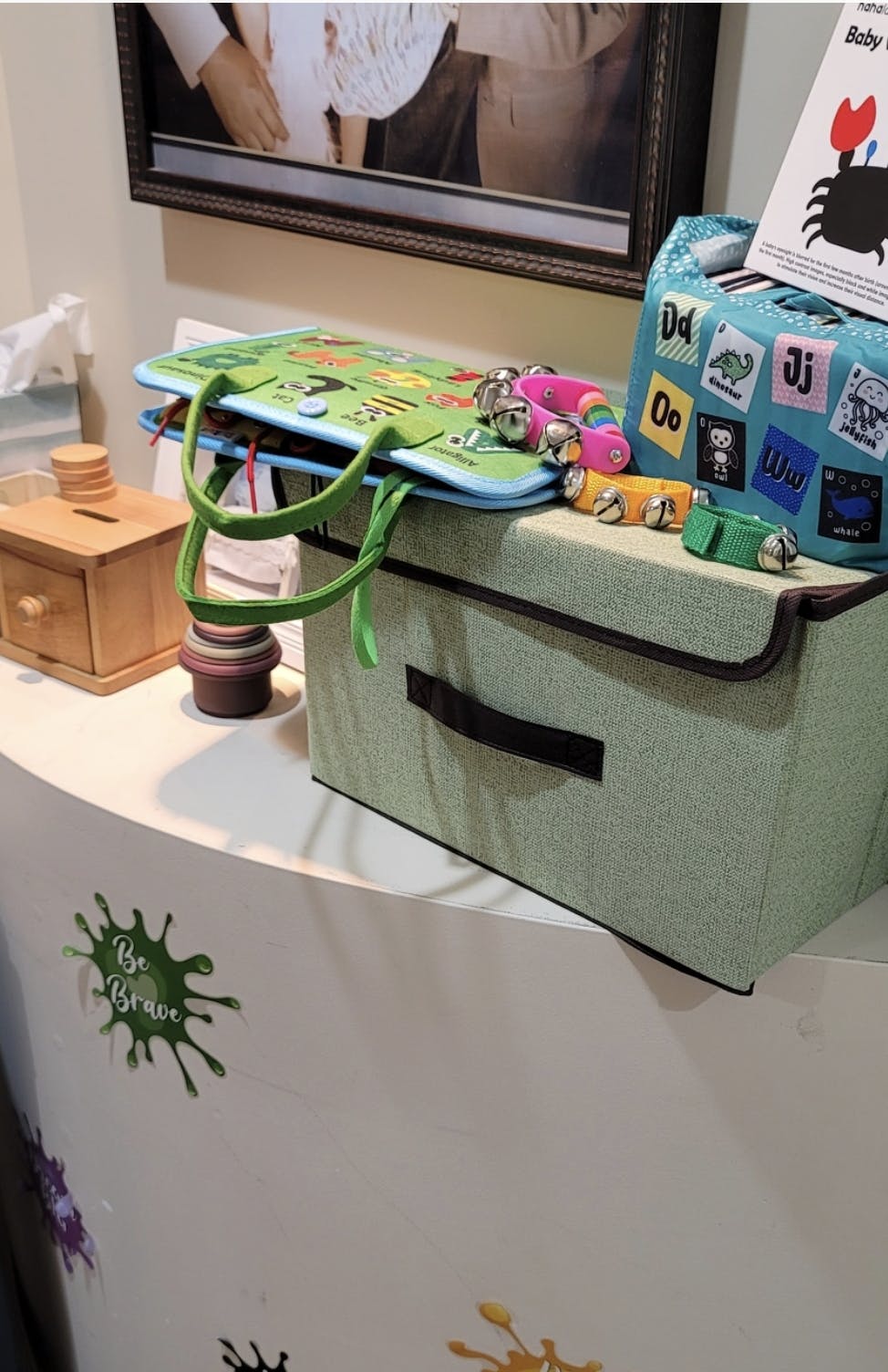 Children's toys including a soft book, shakers, and a wooden box