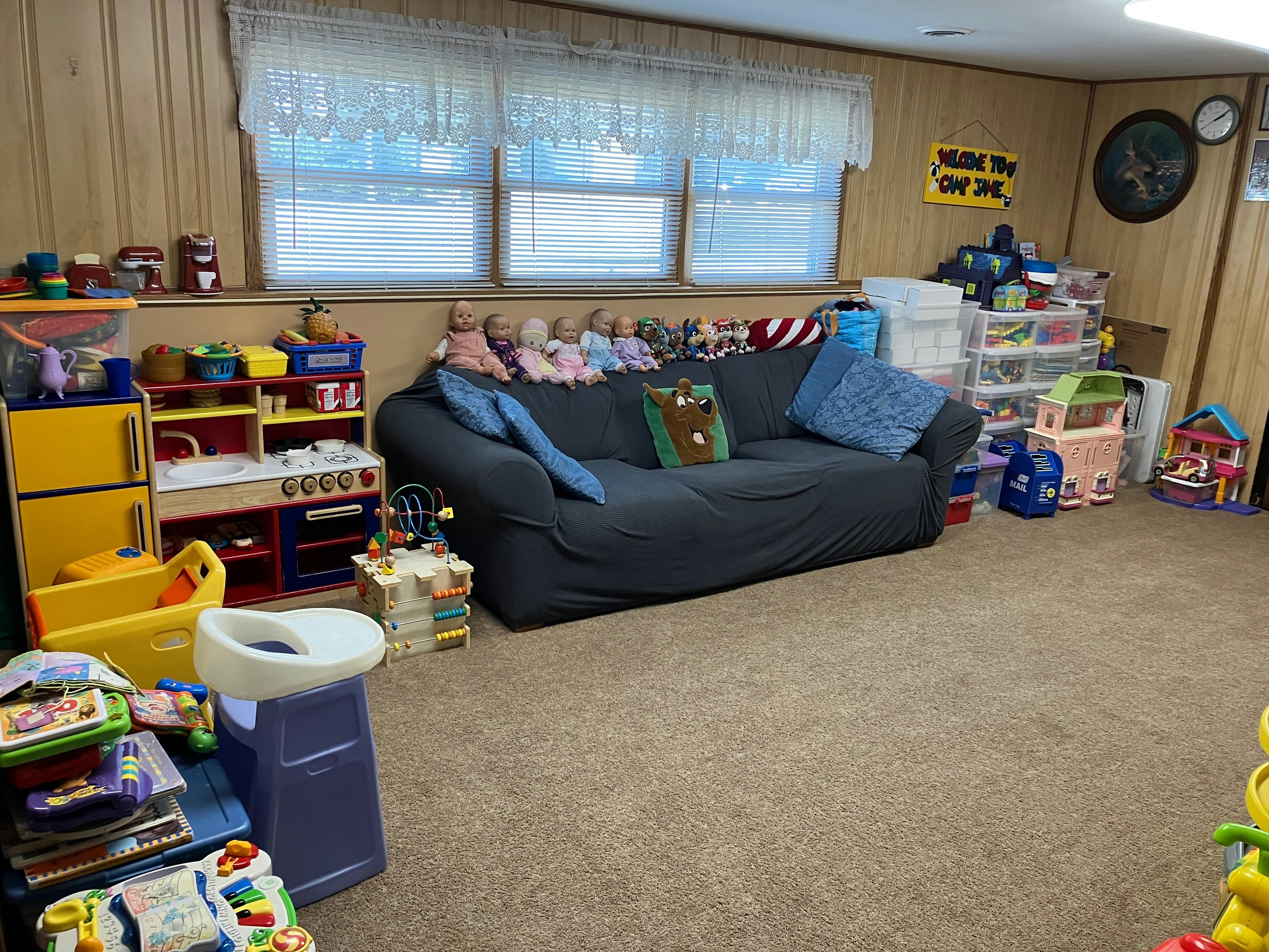 Playroom with a couch, toys, and windows