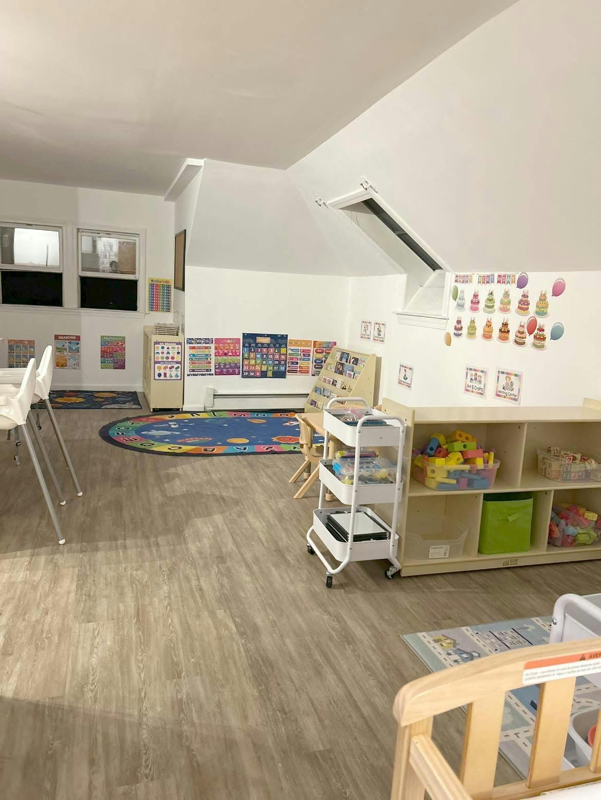 Classroom with colorful decorations, rug, and shelves with toys on shelves