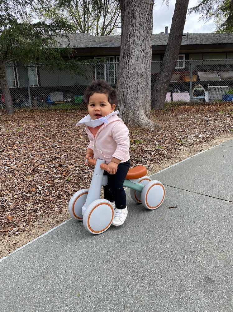 Child standing with a small balance bike